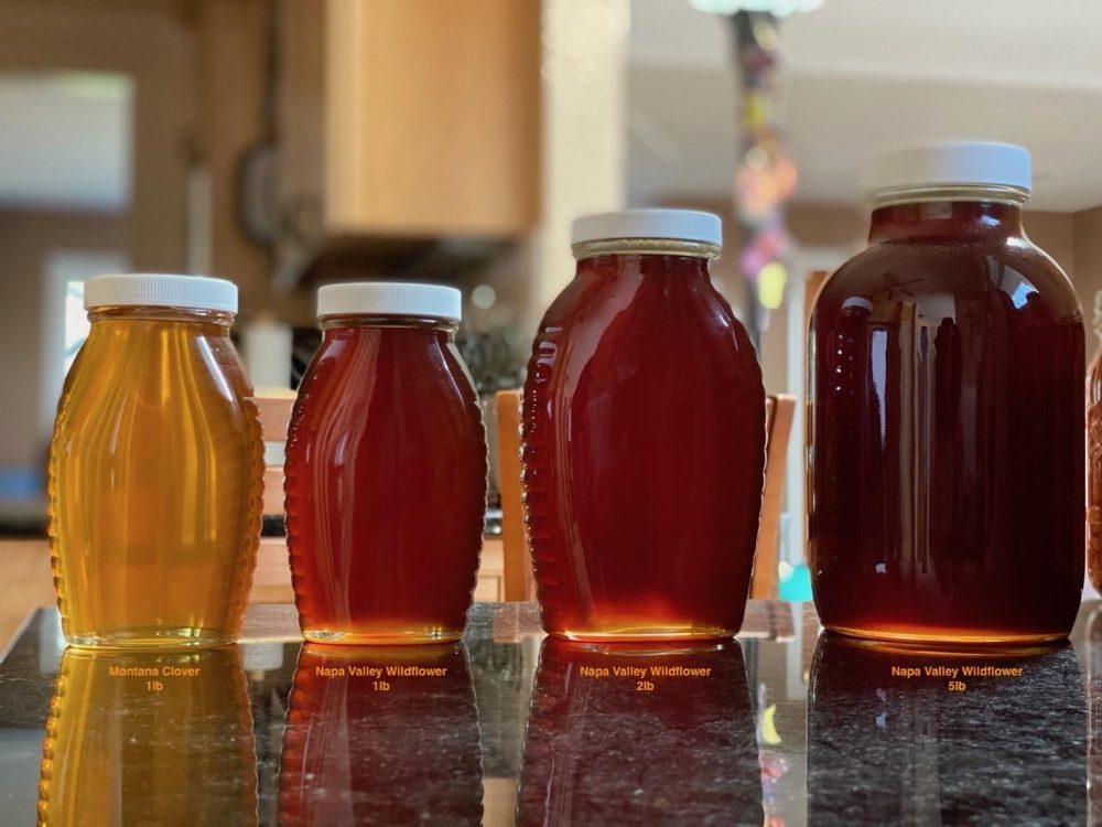 The Queen's Apiary honey in four sizes — Montana Clover 1 lb, and Napa Valley Wildflower 1 lb, 2 lb, and 5 lb jars